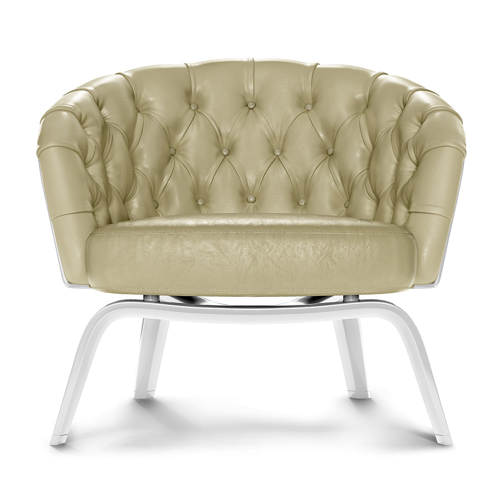 Beige tufted leather lounge chair with buttoned back, rounded arms, and white curved metal legs.