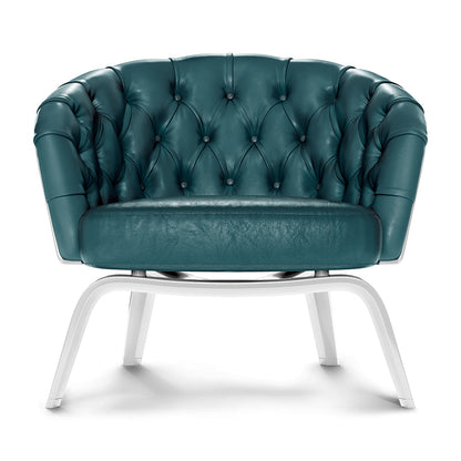 Teal tufted leather lounge chair with curved arms, button tufted back, and white metal legs.