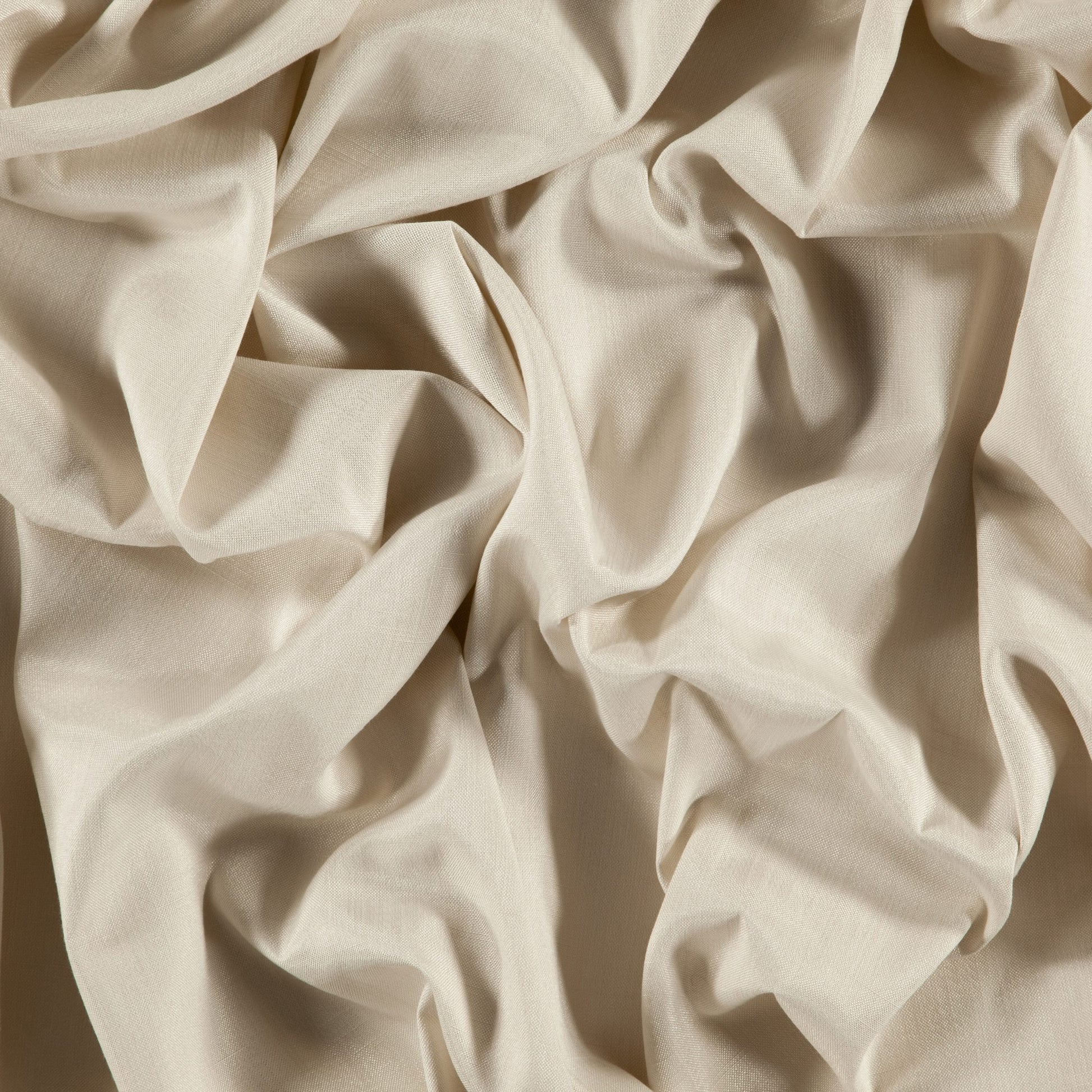 Creamy beige linen-like fabric with soft drapes and folds; textured weave, ideal for clothing or home decor.