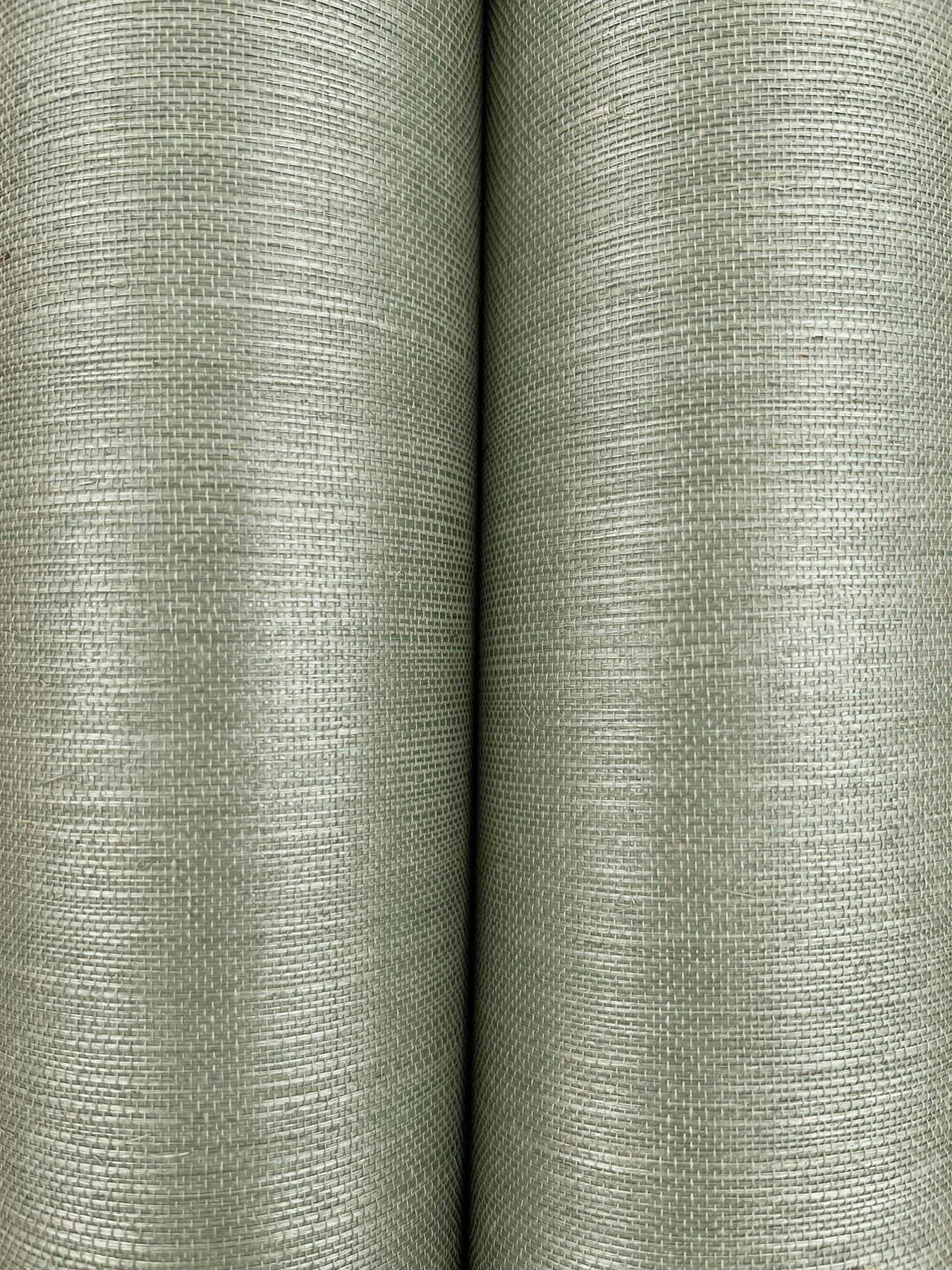 Two olive-green grasscloth wallpaper rolls with a linen-like weave.
