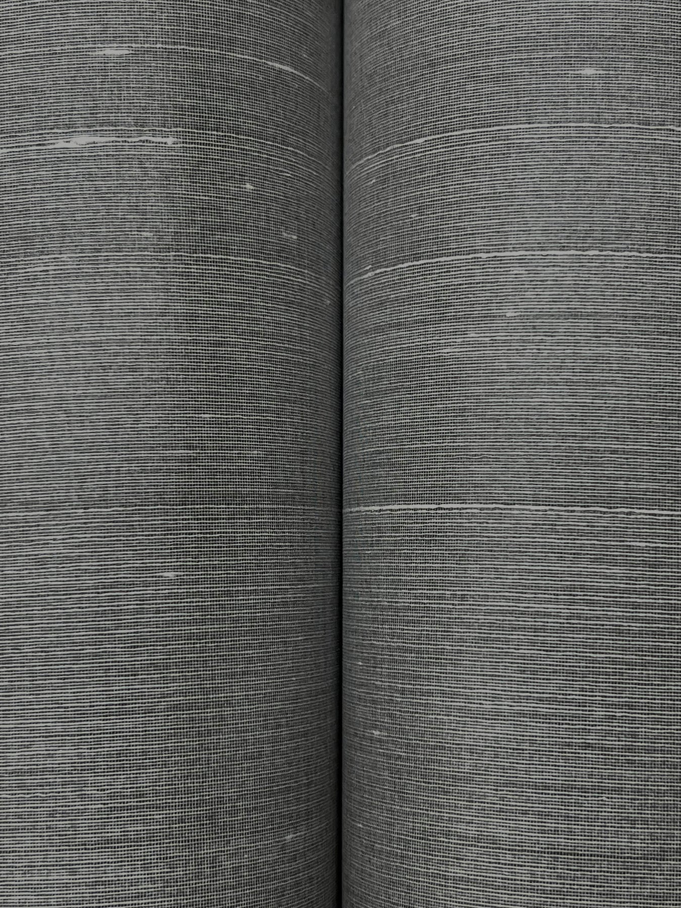 Two rolls of graphite wallpaper with a fine woven texture and linen-like gray finish.