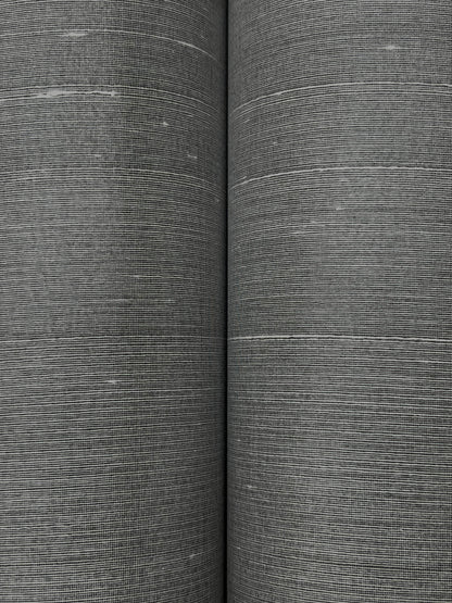 Two rolls of graphite wallpaper with a fine woven texture and linen-like gray finish.