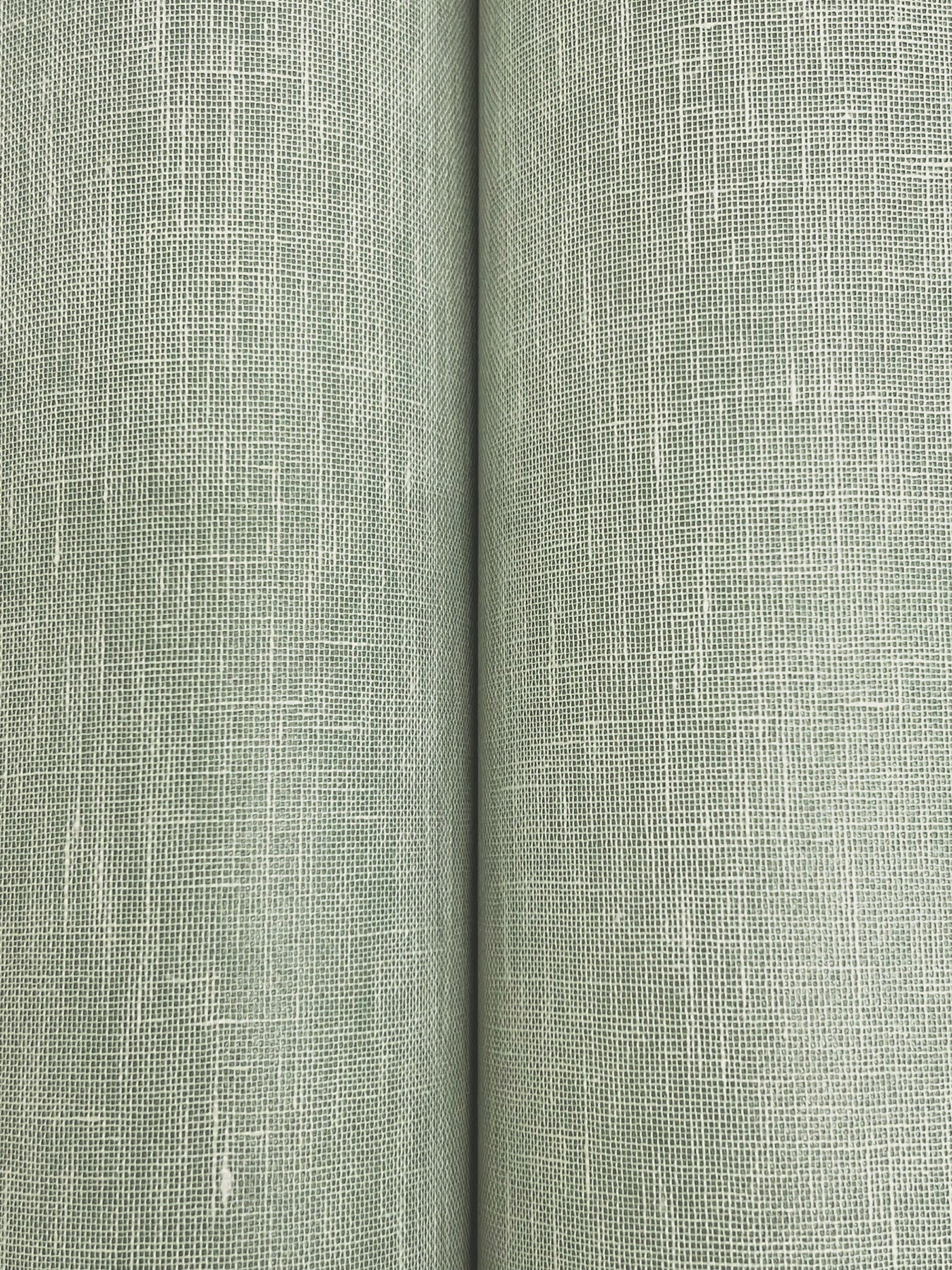 Close-up of sage green linen-look wallpaper with a textured crosshatched weave and a central seam.