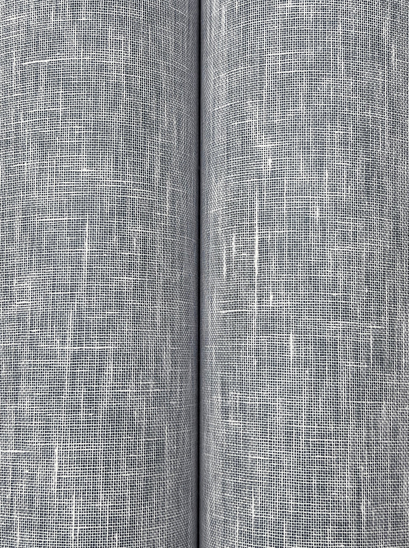 Close-up of blue linen-like wallpaper with a woven texture, white irregular threads and a subtle crosshatch.