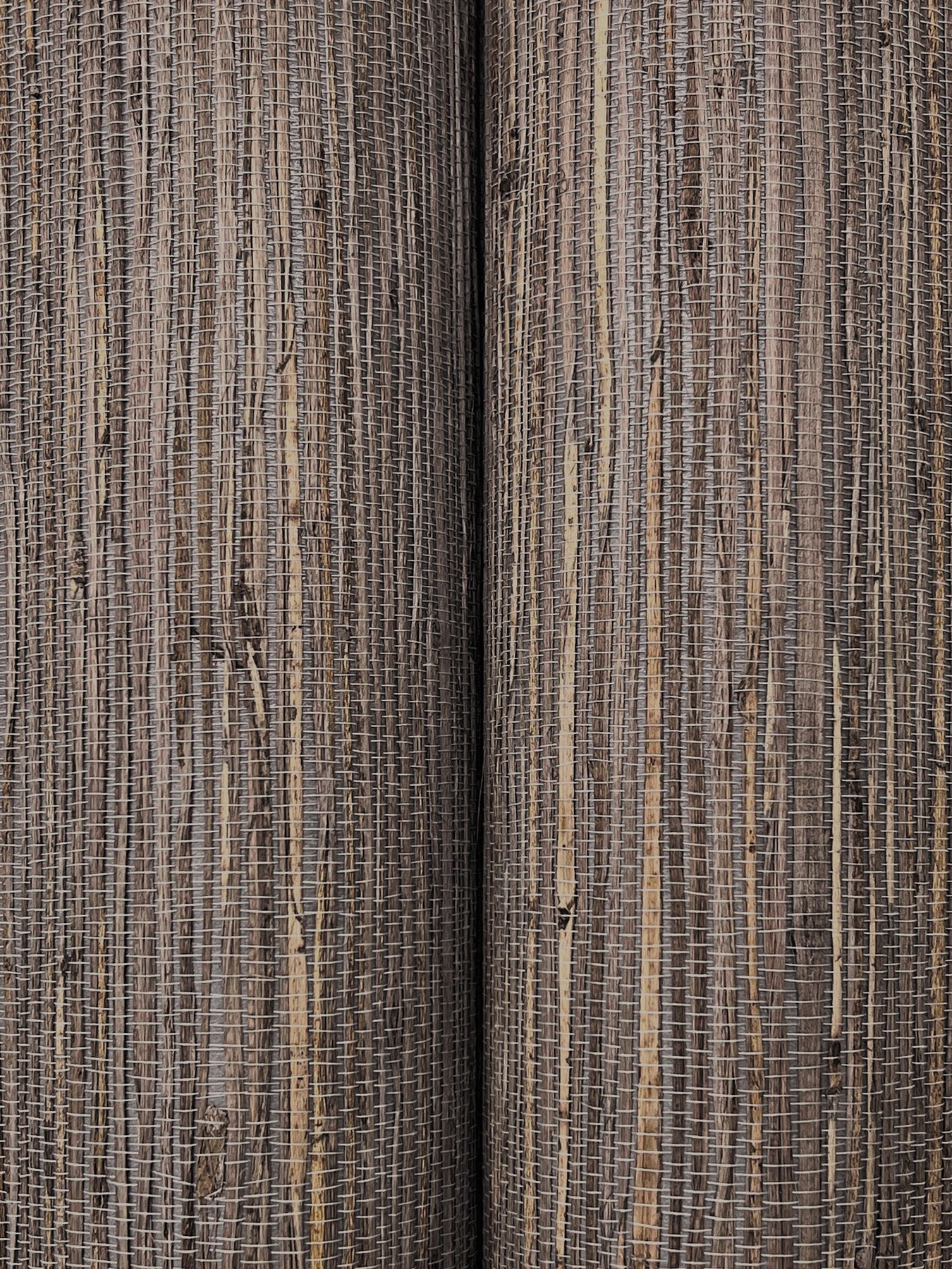 Close-up of striped woven rug fabric in beige and brown tones with a textured jute-like weave.