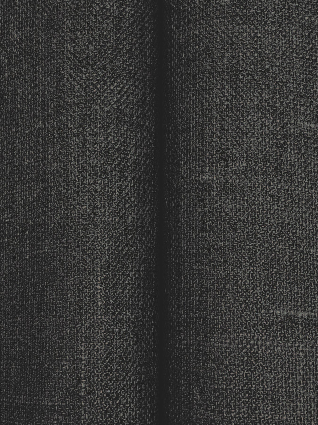 Close-up of charcoal woven fabric with subtle grid texture and soft folds; ideal for upholstery or curtains.