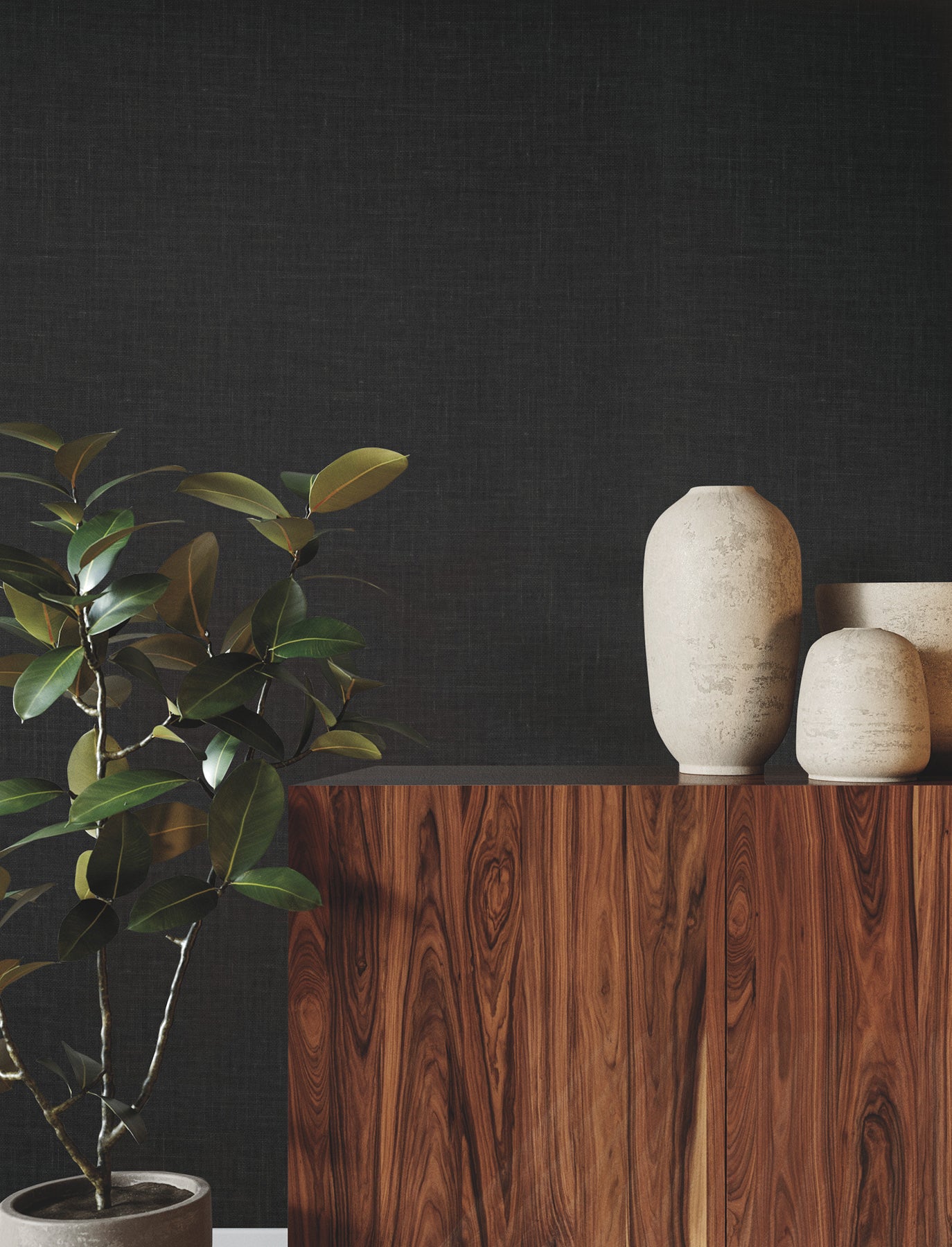 Dark textured wall behind a walnut wood cabinet topped with three beige ceramic vases and a leafy potted plant on the left.