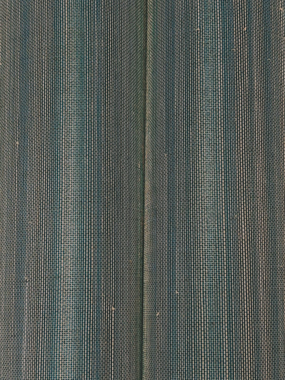 Close-up of teal, gray and blue striped wallpaper with a woven grasscloth texture.