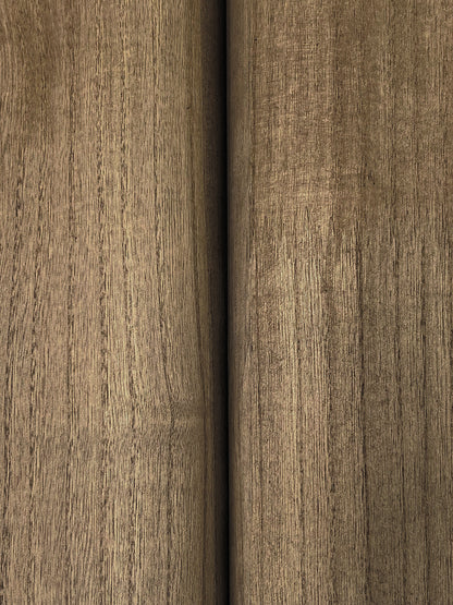 Close-up of brown wood veneer with vertical grain, seam between two panels, warm oak-like finish.