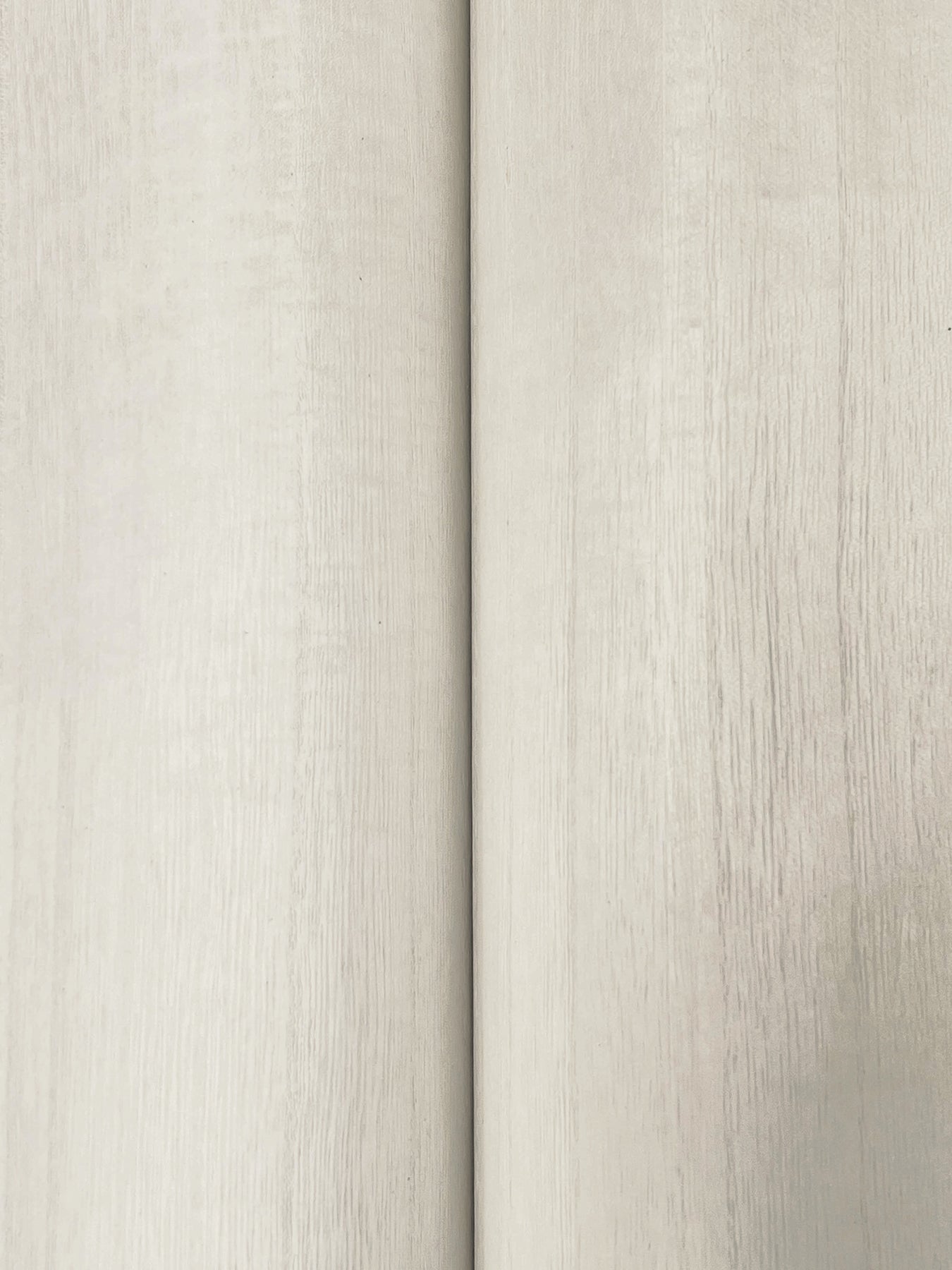 Close-up of light beige wood-veneer wallpaper with subtle grain and a narrow vertical seam.