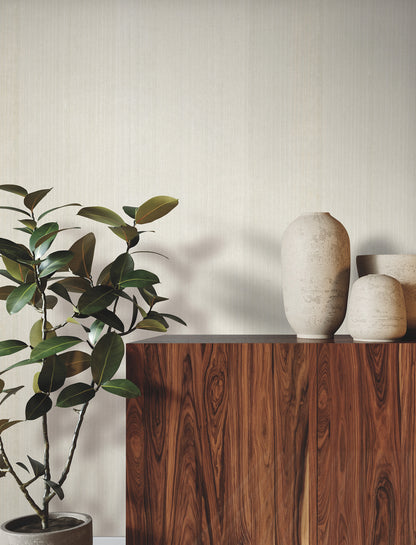 Dark wood sideboard & beige ceramic vases & a leafy plant against a pale wall; Magnolia wood veneer wallpaper design.