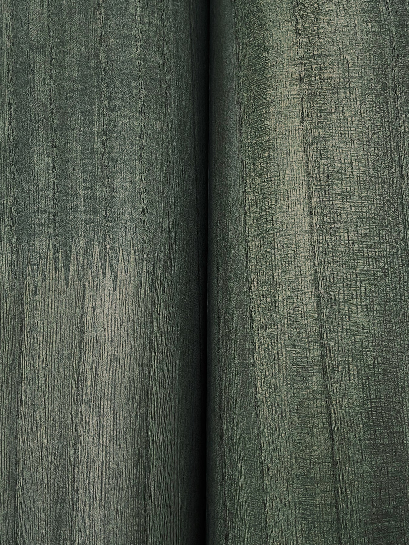 Close-up of two olive-green textured upholstery fabric bolts with visible grain and seam.