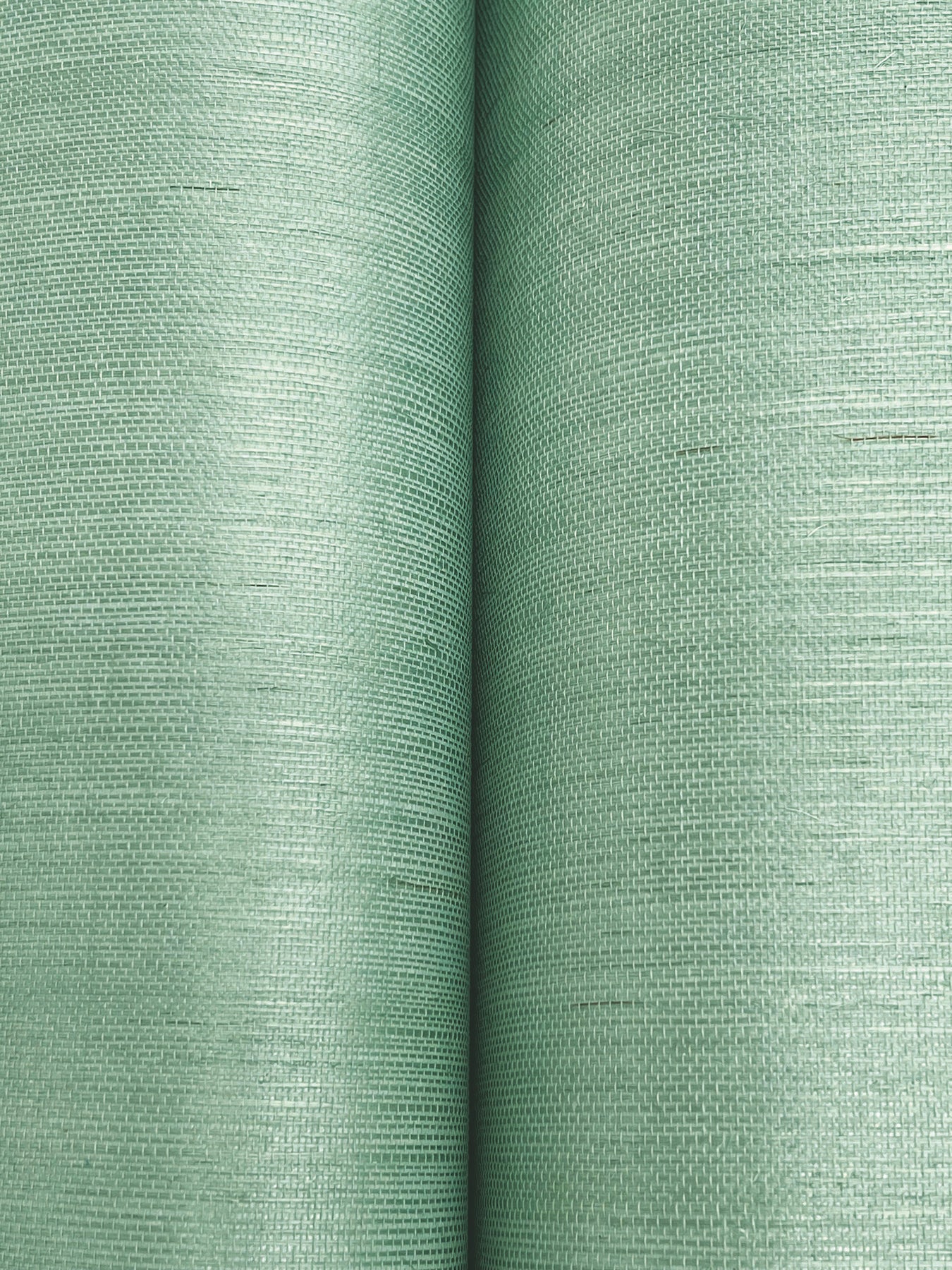 Close-up of two sage green linen-textured fabric rolls, woven pattern and soft matte finish, ideal for upholstery.