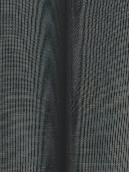 Close-up of dark grey-green wallpaper with a tight grid pattern; two rolled wallpaper edges visible.