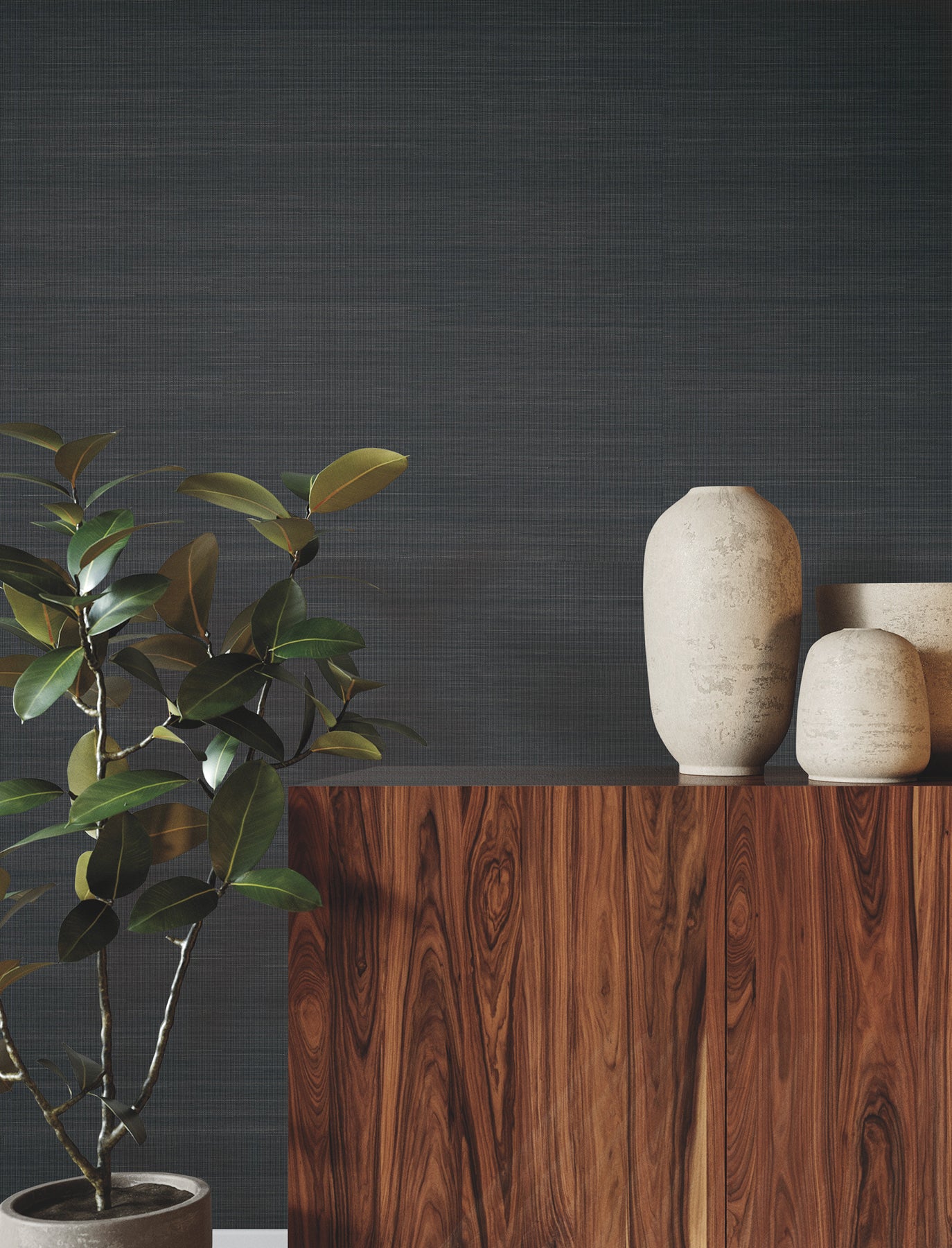 Peppercorn grasscloth wallpaper on a dark textured wall, with a mid-century wooden sideboard, tall cream ceramic vases, and a leafy potted plant in front.