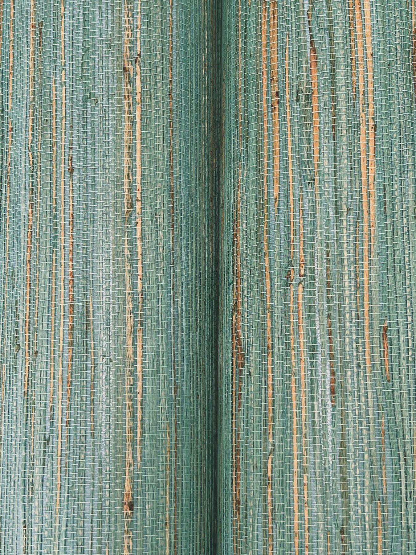 Close-up of teal-green woven fabric with slim beige vertical stripes and a textured ribbed weave.