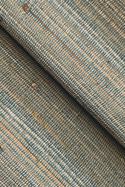 Close-up of grasscloth wallpaper texture with blue, tan & gray threads in a small rectangular grid; rolled edge.