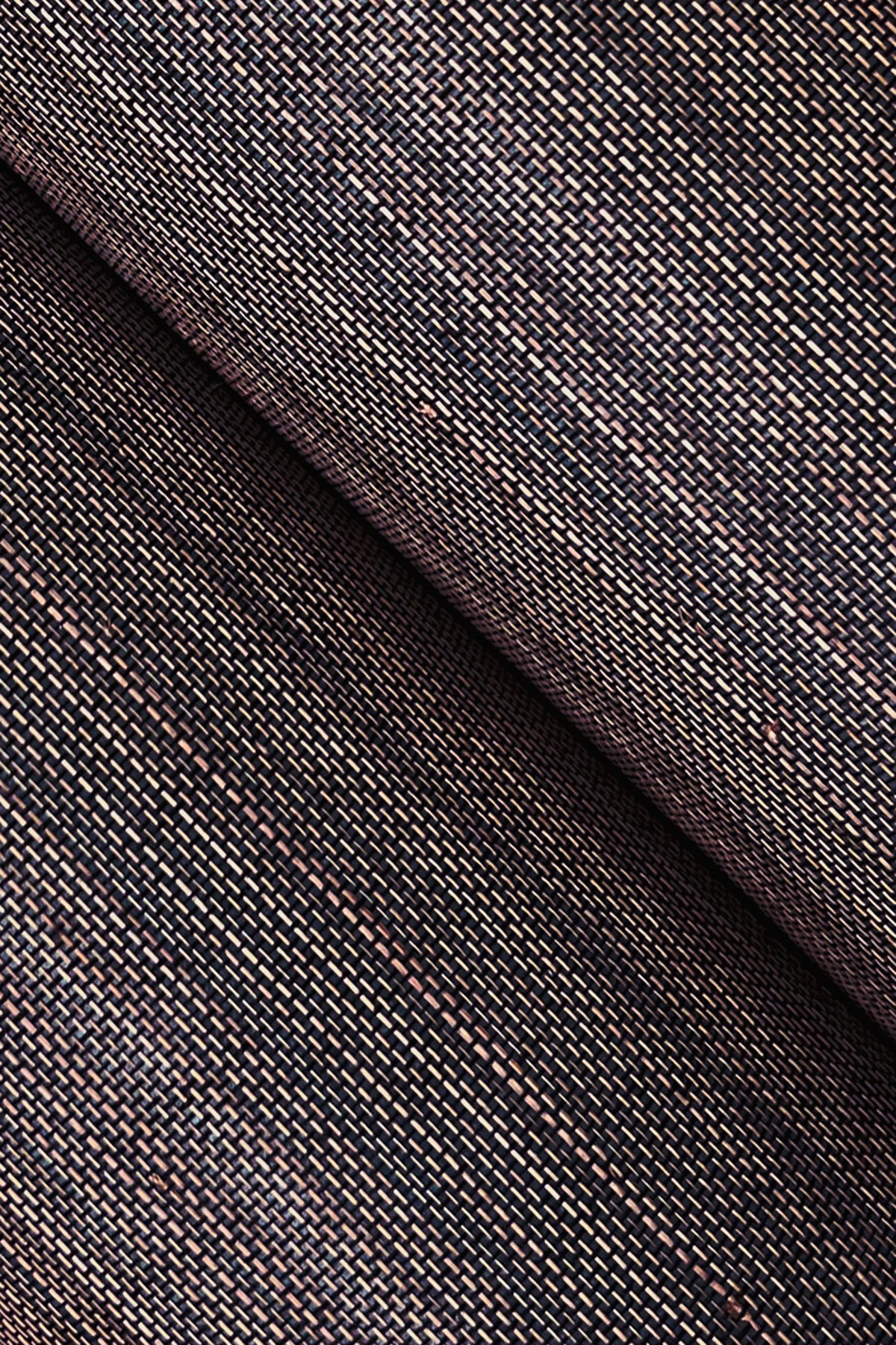 Close-up of grasscloth wallpaper texture in black with multicolor flecks and a diagonal fold.