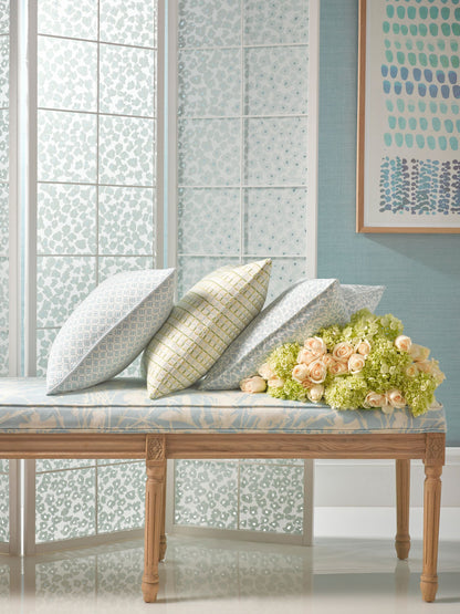 Wood bench with a marble top, three patterned cushions gray & pale yellow plaid, and a pink rose bouquet against a teal wall.