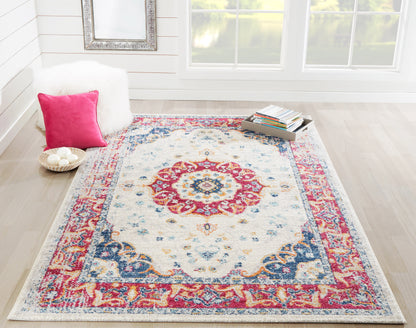 Oriental-style area rug with ivory field, rich red and blue border and central medallion in a bright cozy living room.