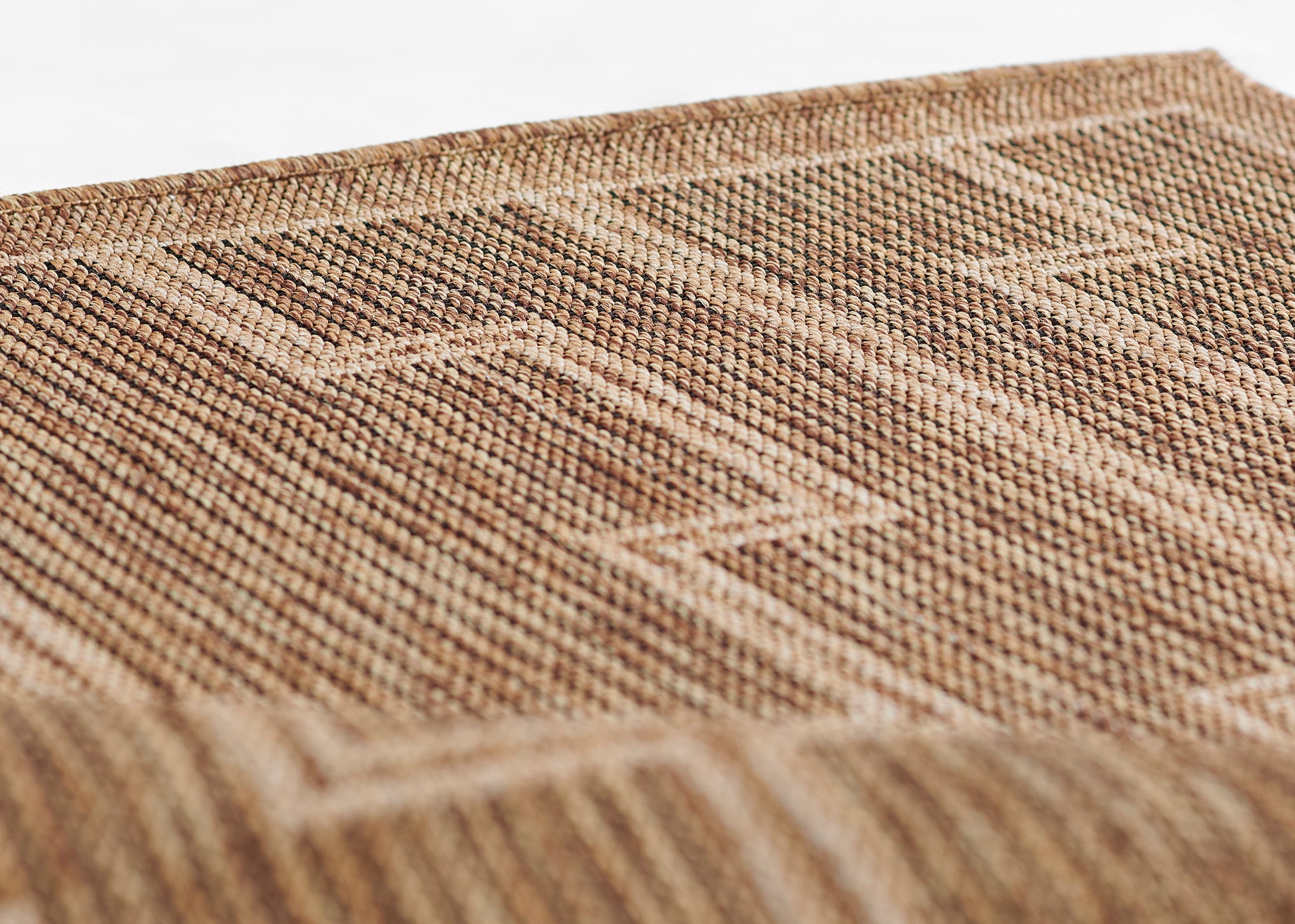 Natural brown jute rug with a geometric woven pattern and textured surface.