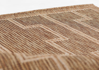 Natural brown jute rug with a geometric woven pattern and textured surface.