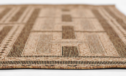 Rectangular natural-fiber rug with beige and brown geometric patchwork and fringe trim