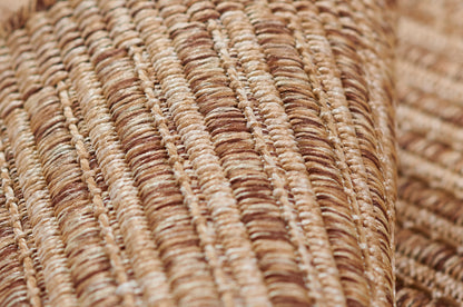 Natural beige and tan braided straw weave with thick fibers; rustic wicker rug.