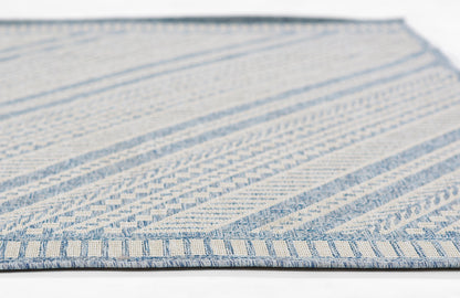 Blue and off-white woven rug with geometric stripes and blue border fringe.