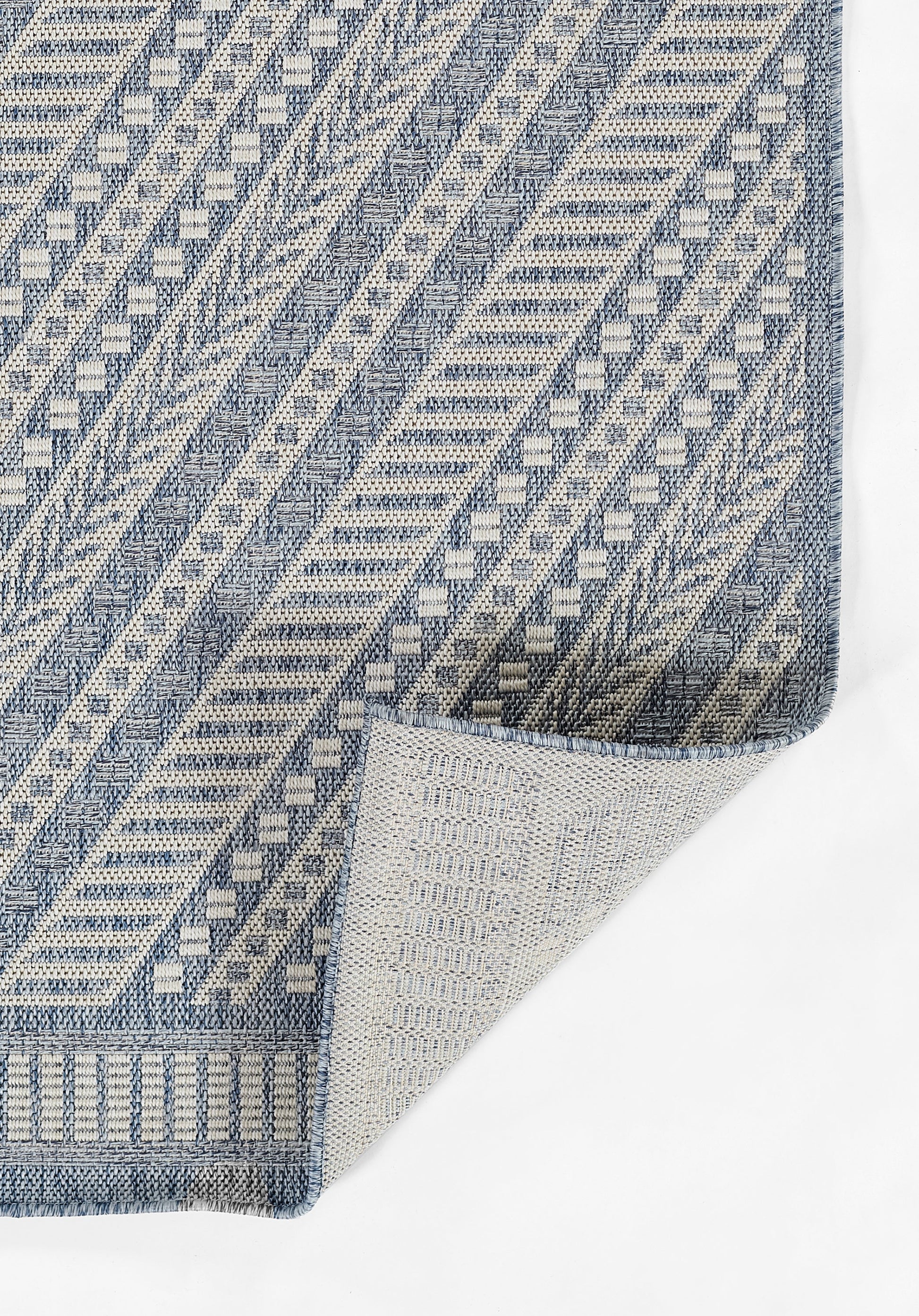 Blue and ivory geometric woven rug with chevron and square patterns and textured weave.
