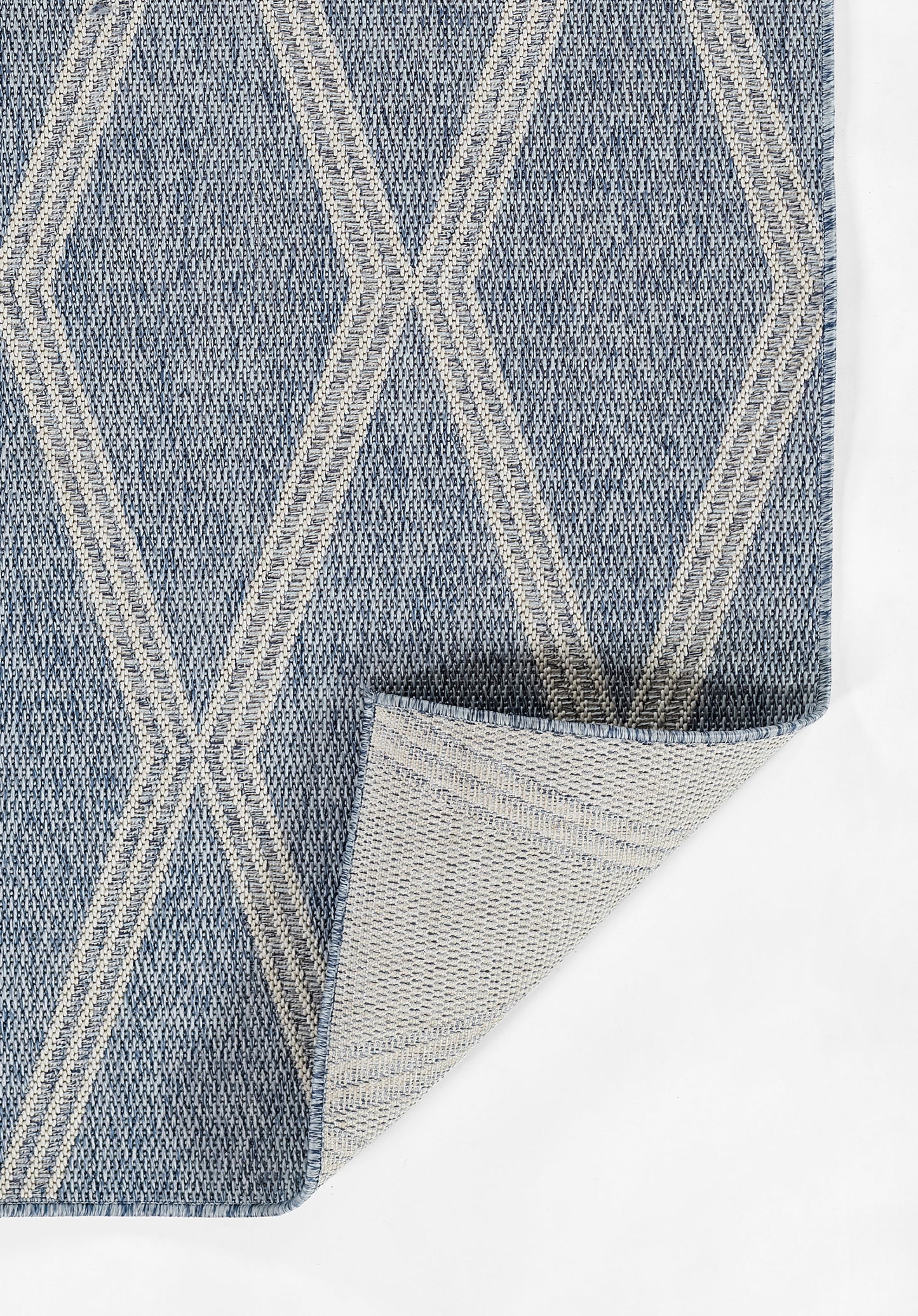 Blue woven rug with white geometric diamond lattice pattern; textured textile with folded corner showing underside.