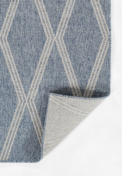 Blue woven rug with white geometric diamond lattice pattern; textured textile with folded corner showing underside.