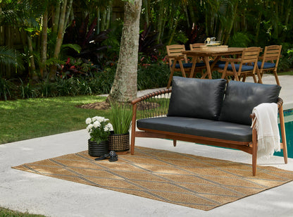 Outdoor natural woven rug runner on a patio, with potted plants nearby.