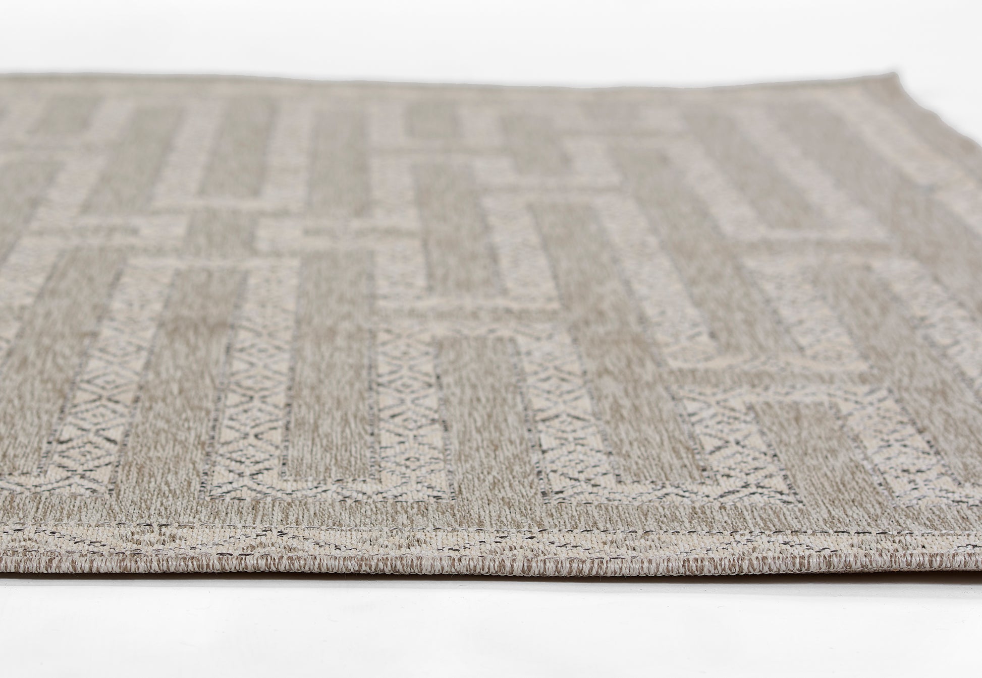 Neutral beige-gray geometric patterned rug with woven texture and stitched border.