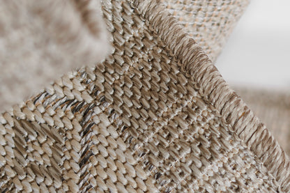 Gray braided jute rug with a thick wrapped edge; rustic textured.