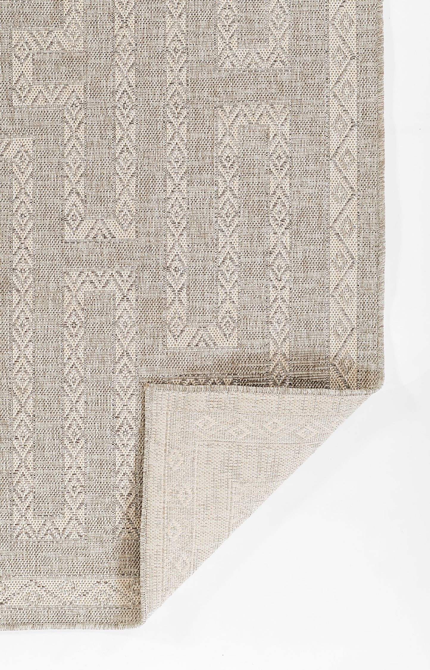 Flatwoven geometric area rug in taupe and cream with diamond motifs; folded corner shows the weave.