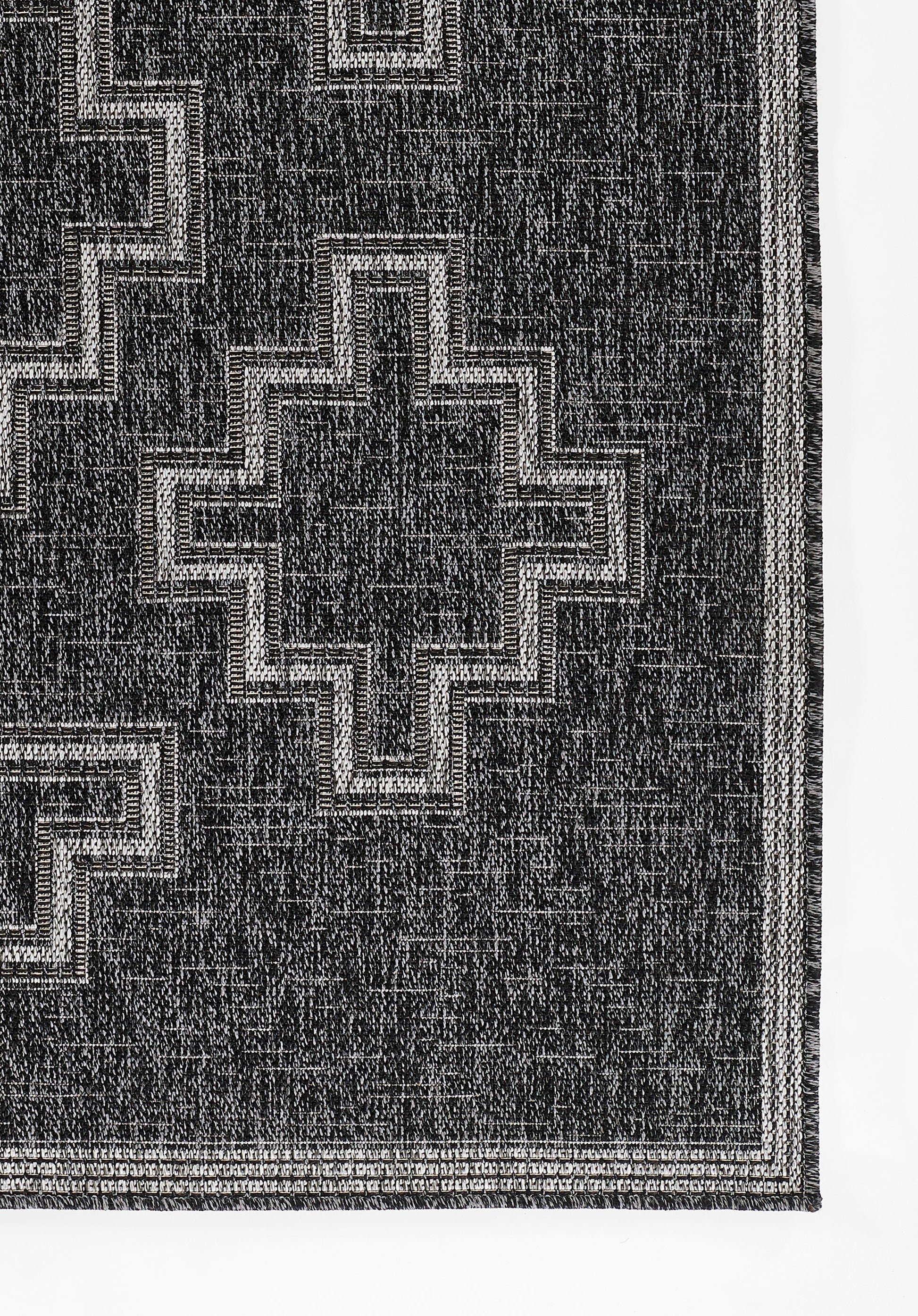 Black rectangular rug on a gray gradient backdrop.