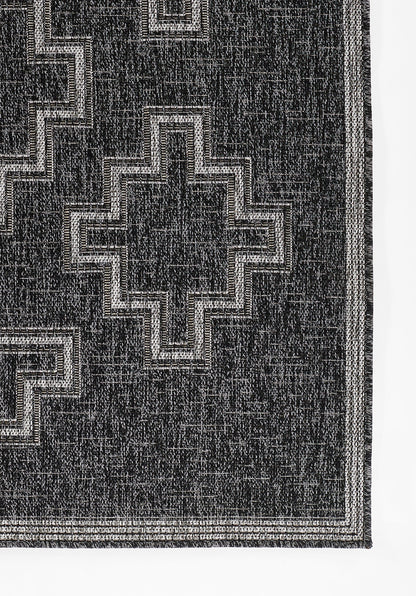Black rectangular rug on a gray gradient backdrop.
