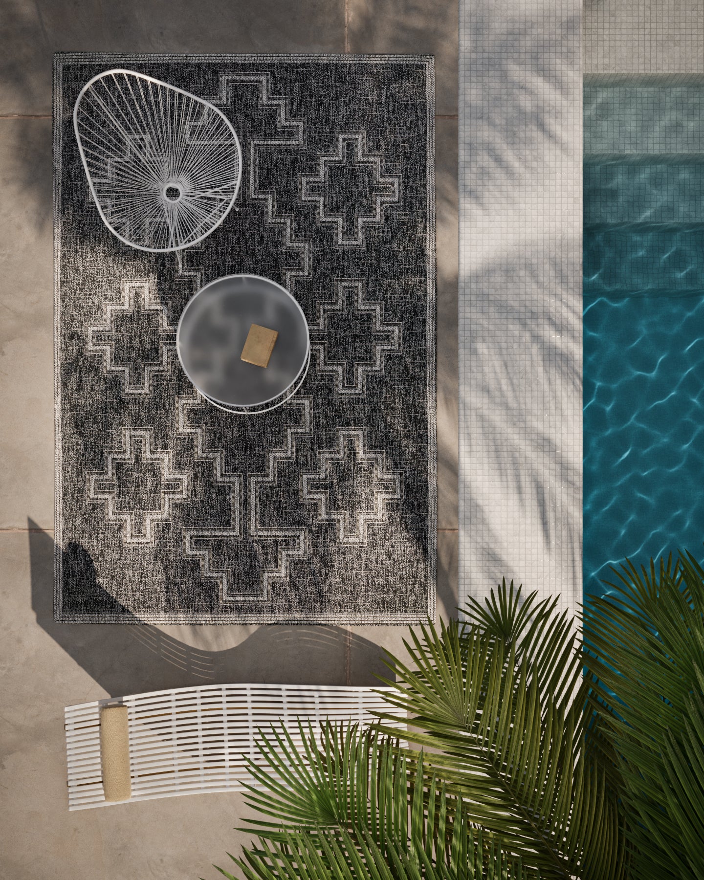Outdoor patio with a black geometric rug with a white cross motif, round glass table, white wire chair, poolside palms.
