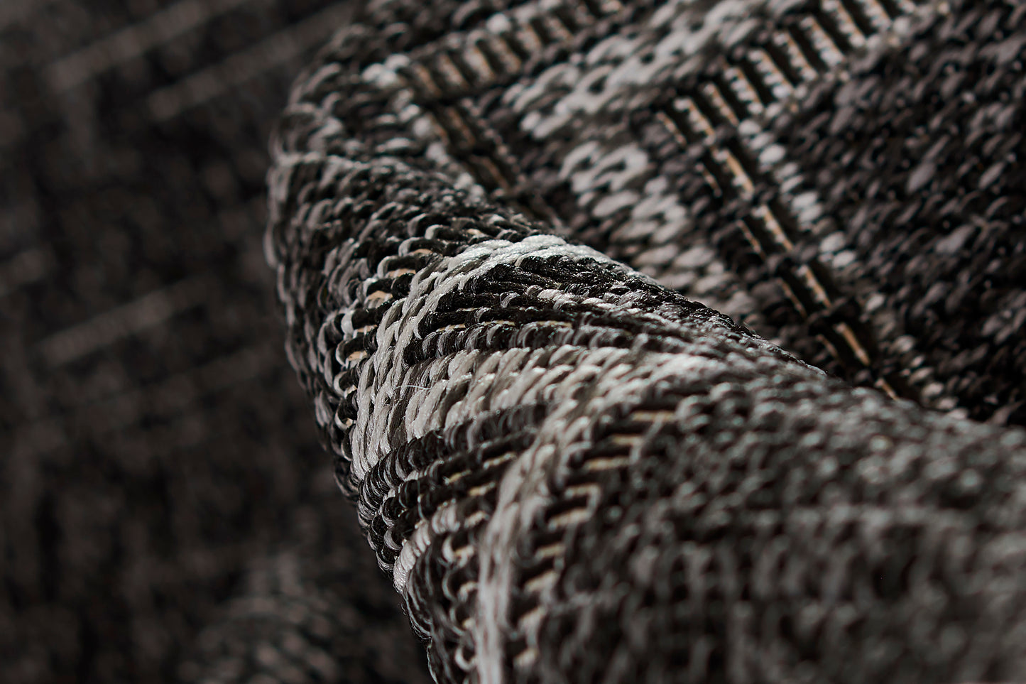 Dark gray and black tweed rug close-up with white flecks and chunky woven texture; size 2' X 3'.