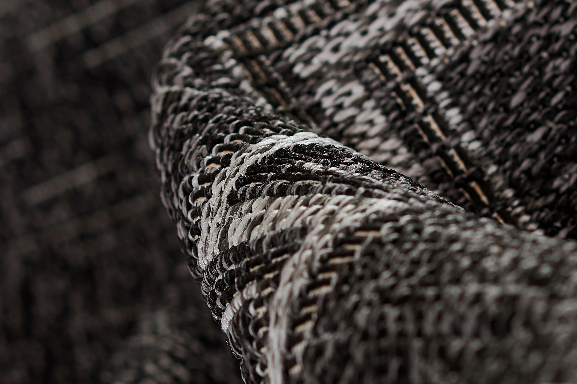 Dark gray and black tweed rug close-up with white flecks and chunky woven texture; size 2' X 3'.
