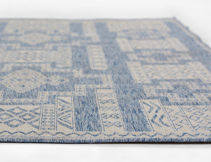 Blue and ivory geometric patterned woven rug; kilim-inspired motifs, flat-weave, rectangular, boho living room floor.