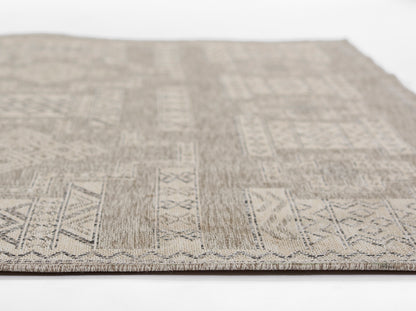 Beige-gray geometric woven area rug with rectangular blocks and zigzag border, close-up view.