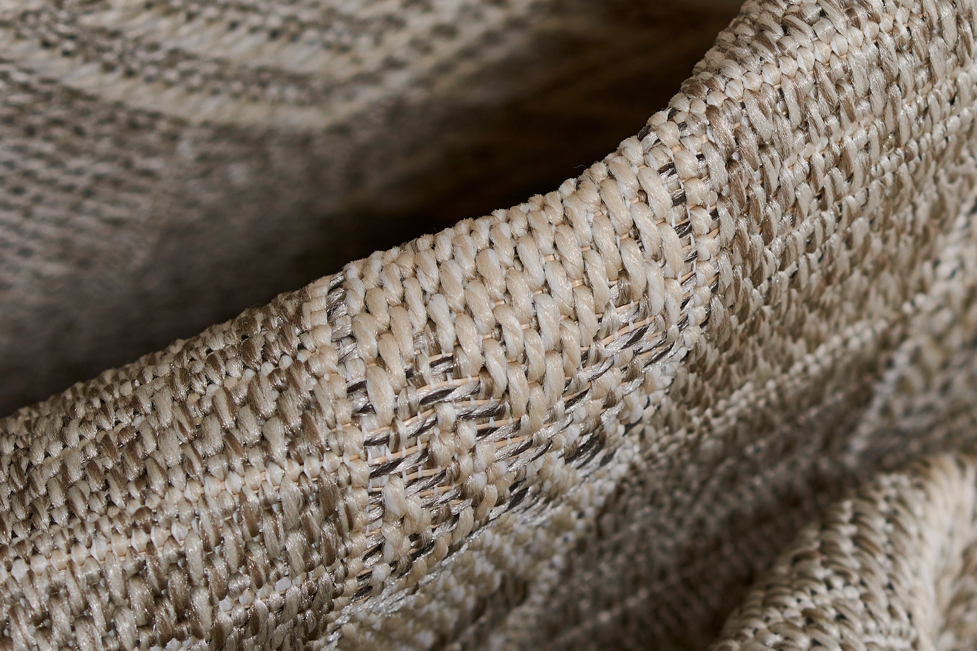 Close-up of beige-gray woven jute texture with chunky strands, rustic rug style.