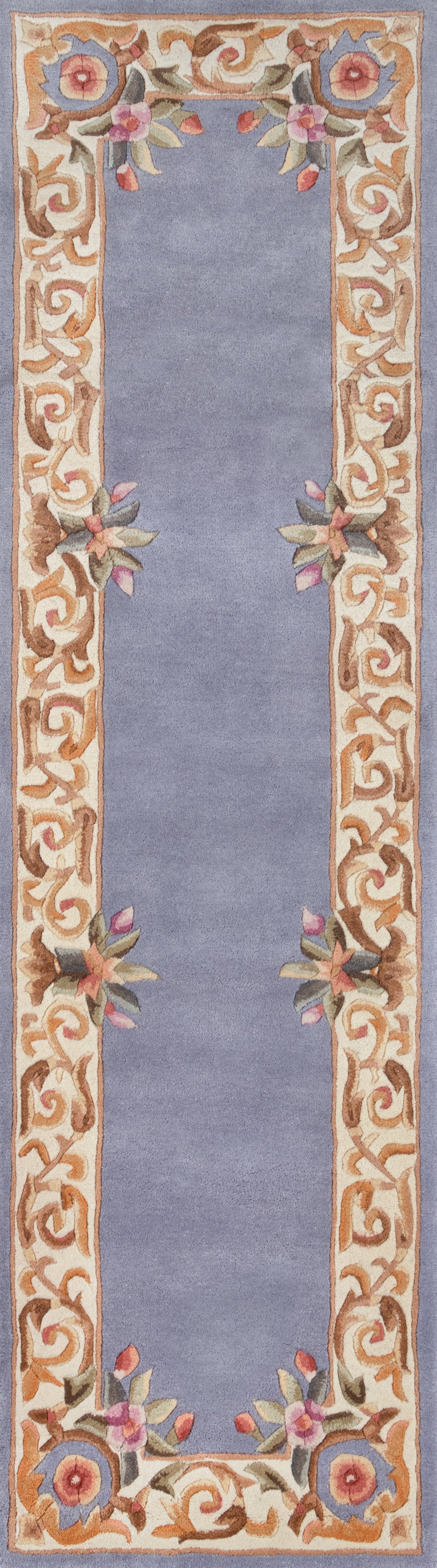 Round blue rug with a cream-gold scrolling border, ornate vine patterns and pink floral clusters along the edge.