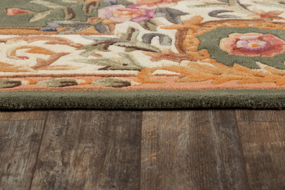 Close-up of a multicolor floral area rug with a dark green border on a wooden floor.