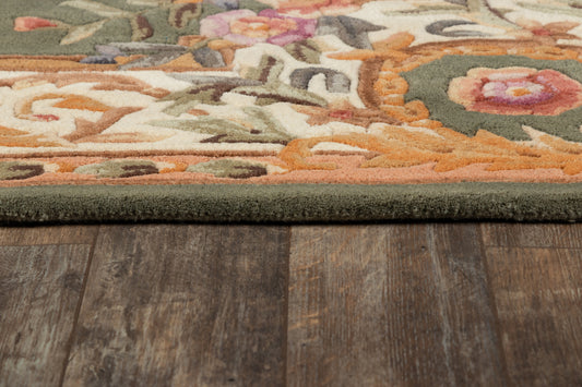 Close-up of a multicolor floral area rug with a dark green border on a wooden floor.