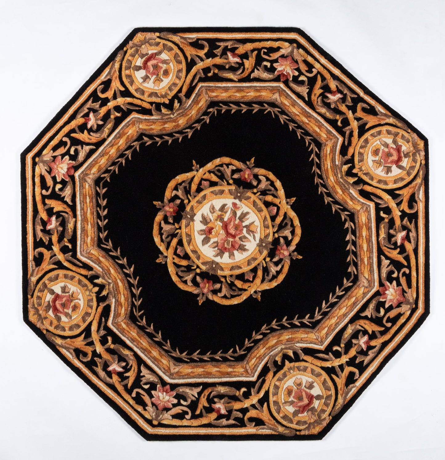 Octagonal black rug featuring gold, bronze and red floral embroidery, central medallion and ornate border.