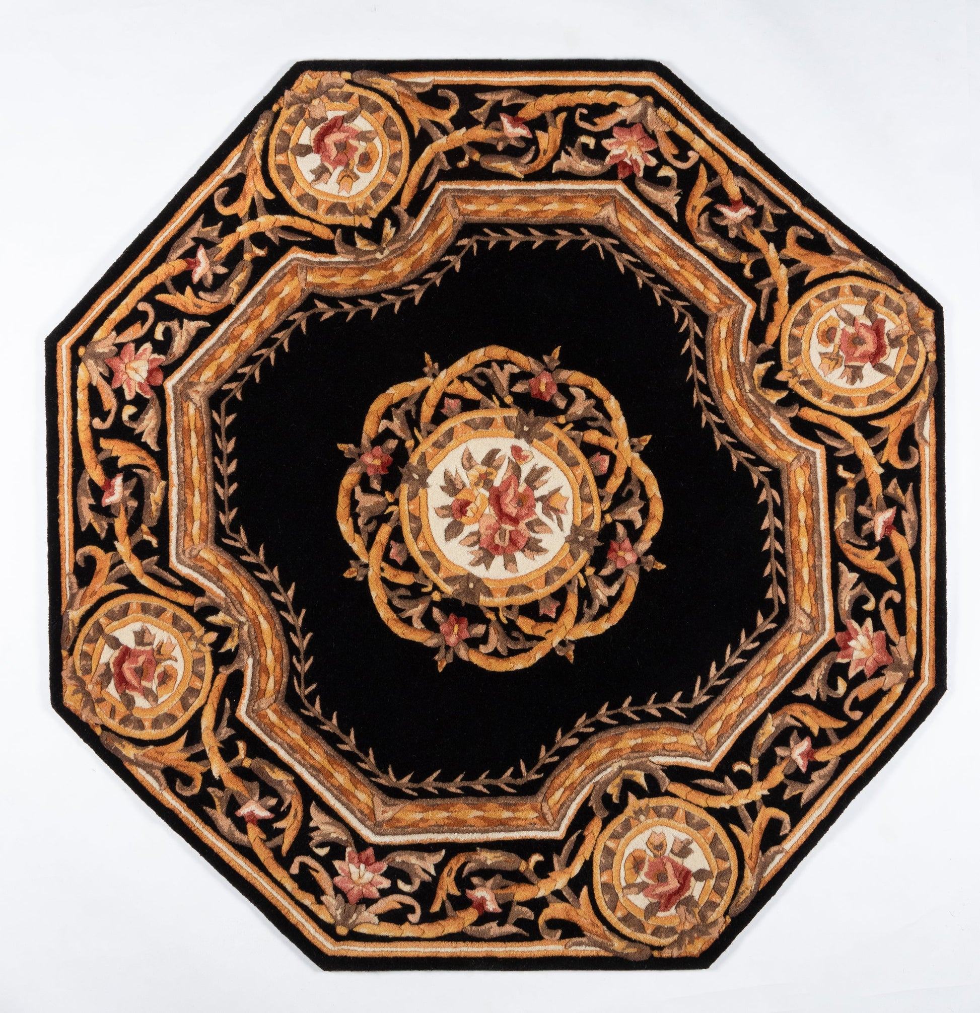 Octagonal black rug featuring gold, bronze and red floral embroidery, central medallion and ornate border.