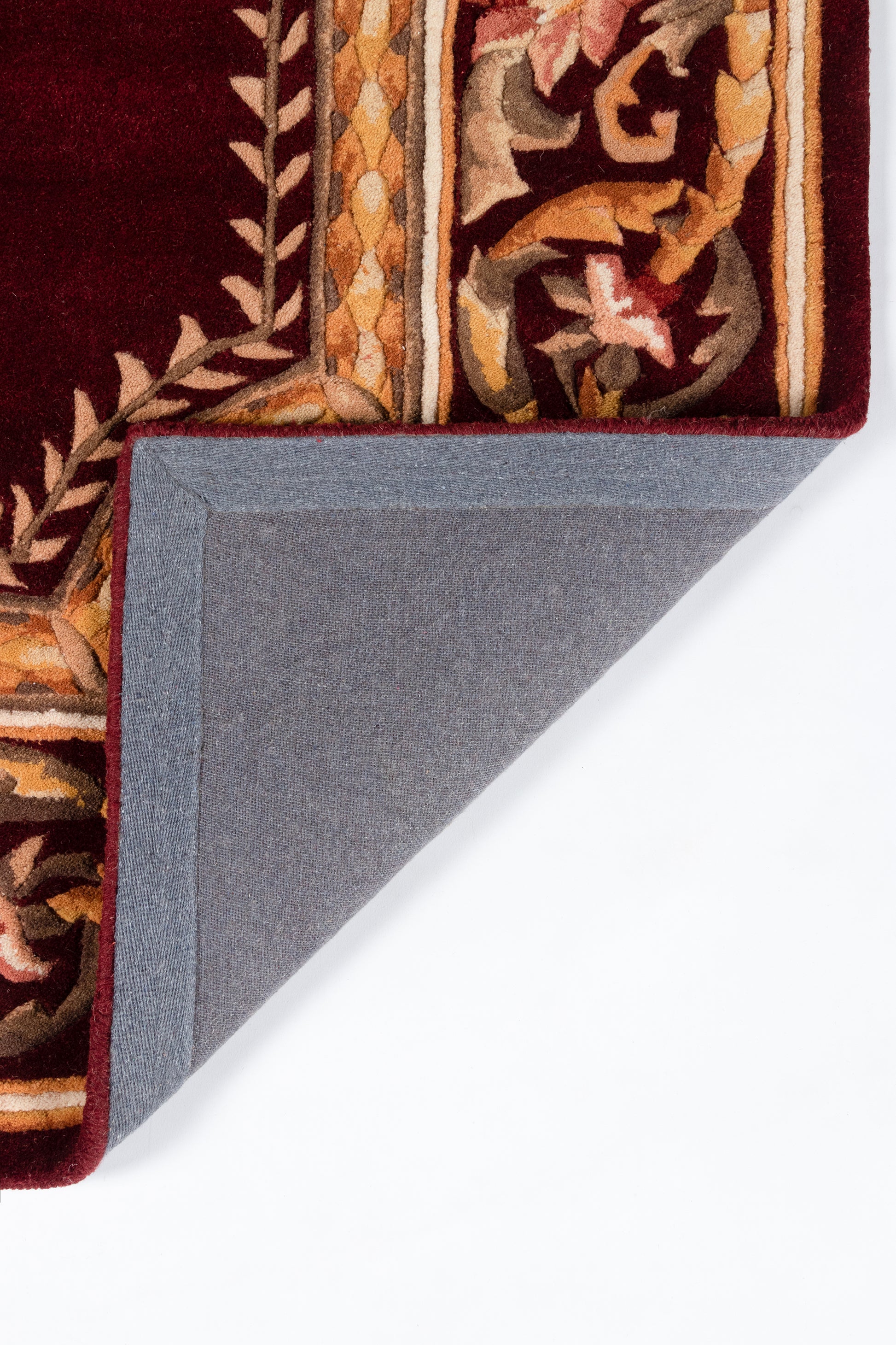 Decorative burgundy oriental rug with gold and tan floral border; folded corner reveals blue-gray underside.